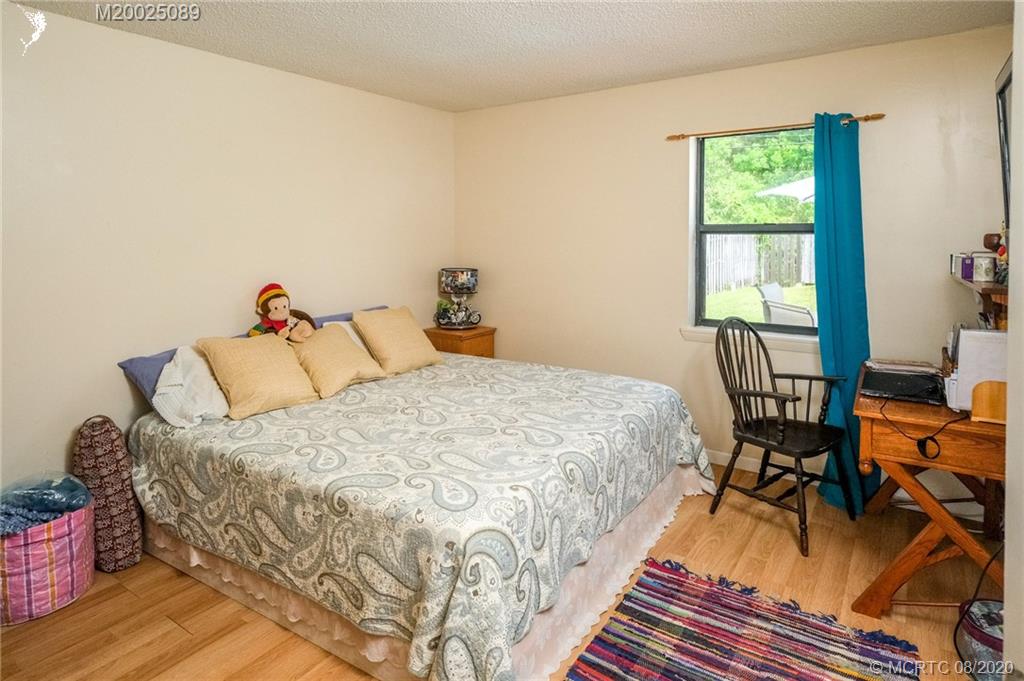 4063 Southeast Jacaranda Street Stuart, FL 34997 - Photo 9 of 34 a bedroom with a bed and wooden floor