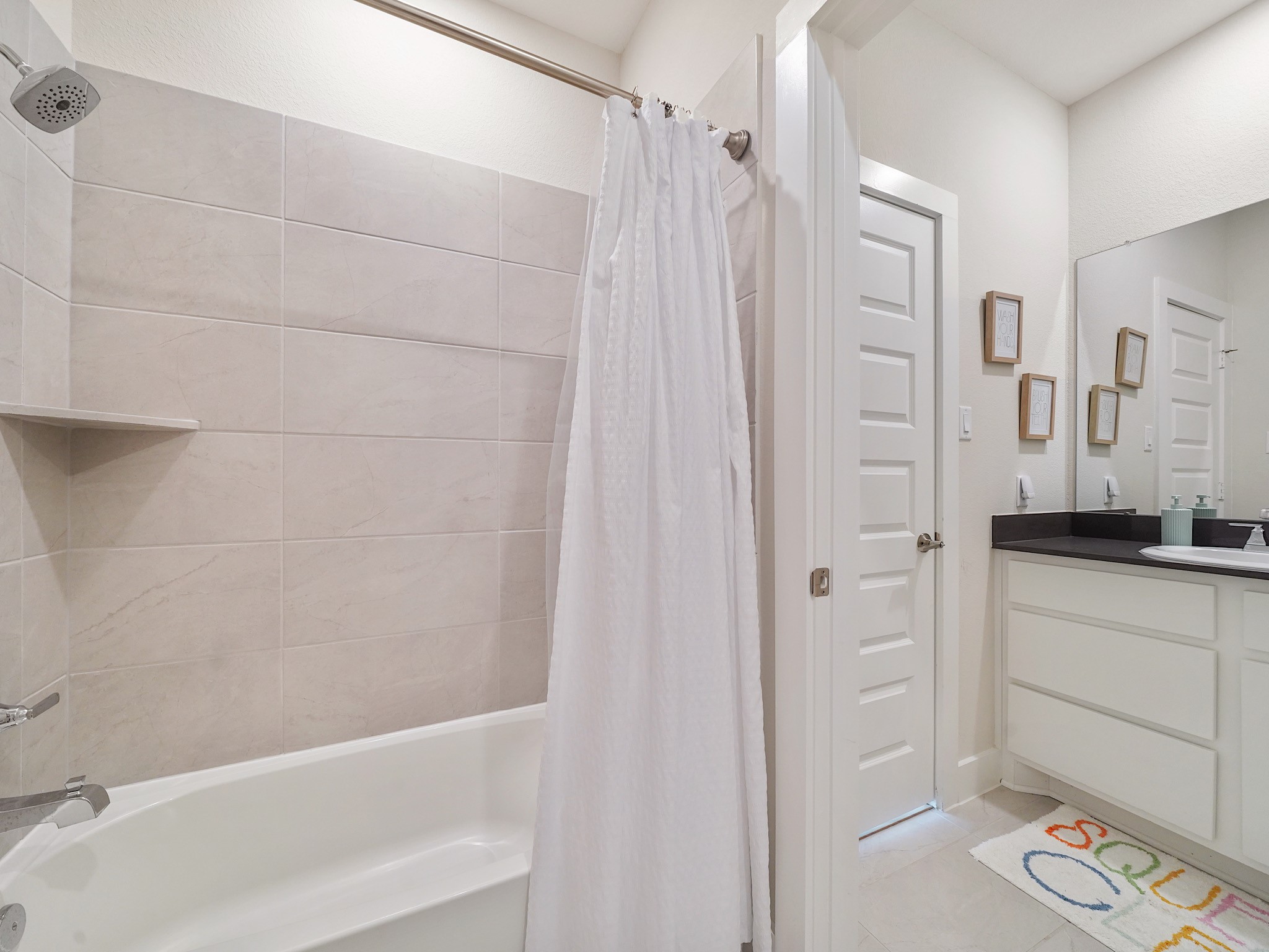 5802 Emerald Ranch Lane Fulshear, TX 77441 - Photo 38 of 45 Clean lines and soft neutral finishes continue throughout the secondary bath, offering a bright and comfortable space with a tub and shower combination ideal for everyday use.