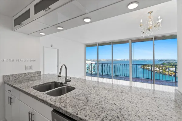 a kitchen with a sink a counter top space and living room