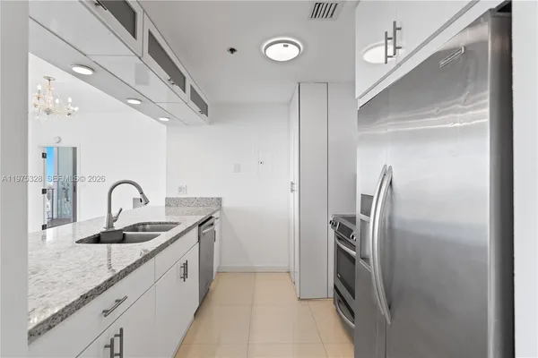 a kitchen with stainless steel appliances granite countertop a sink and a refrigerator