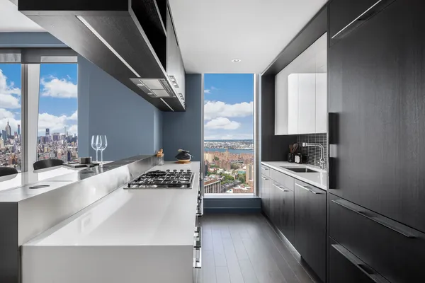 a kitchen with stainless steel appliances granite countertop a sink stove and white cabinets