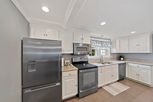 a kitchen with white cabinets stainless steel appliances and sink