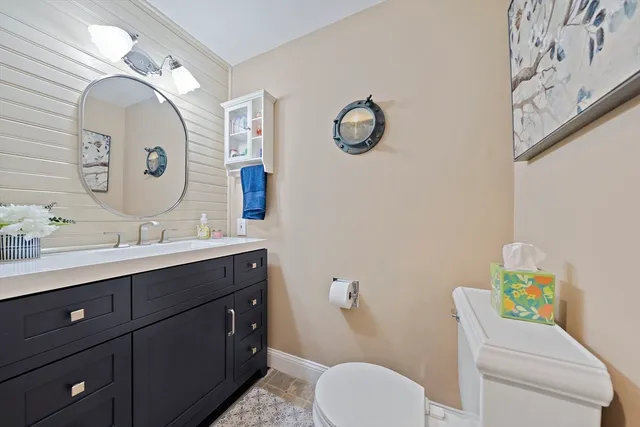 a bathroom with a granite countertop toilet sink and mirror