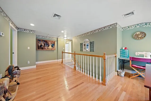 a view of a hallway with workspace and wooden floor