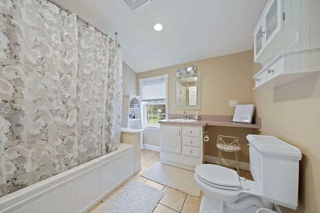 a bathroom with a granite countertop sink toilet mirror and bathtub