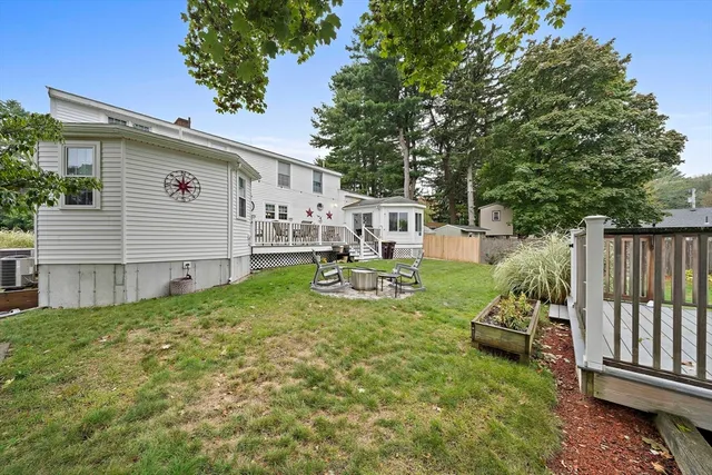 a view of a white house with a small yard and sitting area