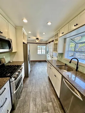 a kitchen with stainless steel appliances granite countertop a stove and a sink
