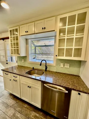 a kitchen with granite countertop a sink and a stove