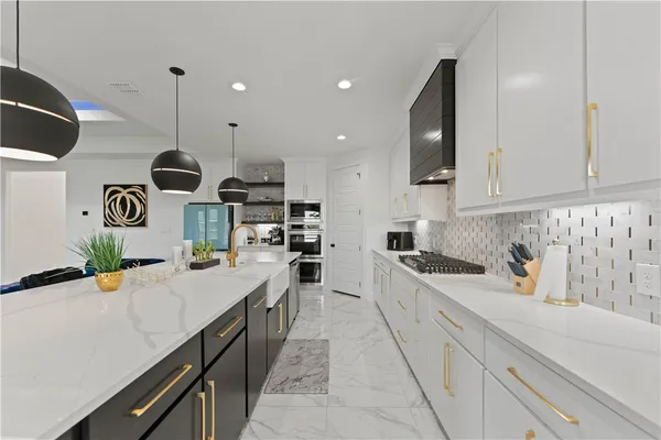 a kitchen with stainless steel appliances granite countertop a sink a stove and a wooden floors