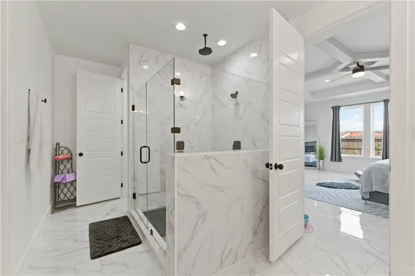 a spacious bathroom with a tub shower and bedroom