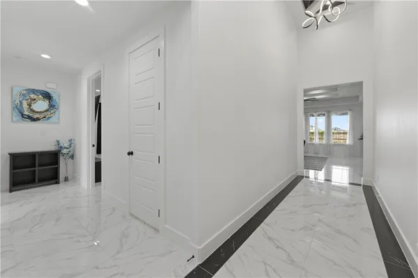 a view of a hallway with wooden floor and a bathroom
