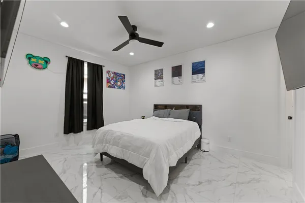 a bedroom with a bed a flat screen tv and a a couch