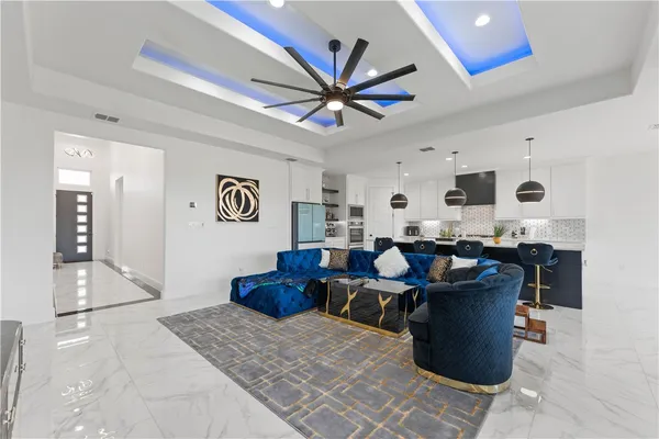 a living room with lots of furniture and ceiling fan