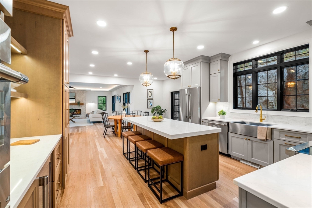 59 Dexter Road Melrose, MA 02176 - Photo 11 of 41 a large kitchen with kitchen island a large island in the center and stainless steel appliances