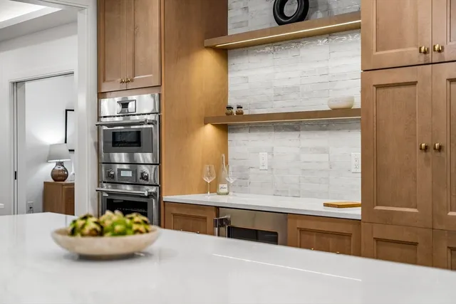 a kitchen with a sink a center island cabinets and stainless steel appliances
