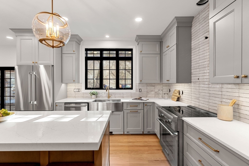 59 Dexter Road Melrose, MA 02176 - Photo 15 of 41 a kitchen with a sink a center island cabinets and stainless steel appliances