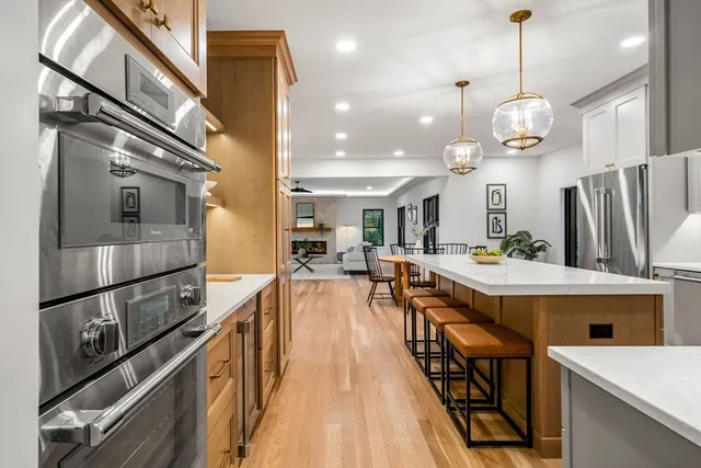 a large kitchen with kitchen island a large island in the center and stainless steel appliances