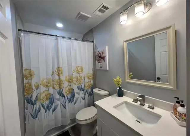 a bathroom with a sink toilet and mirror