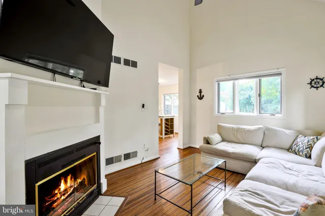 a kitchen with stainless steel appliances granite countertop a refrigerator a stove top oven a sink dishwasher and white cabinets with wooden floor