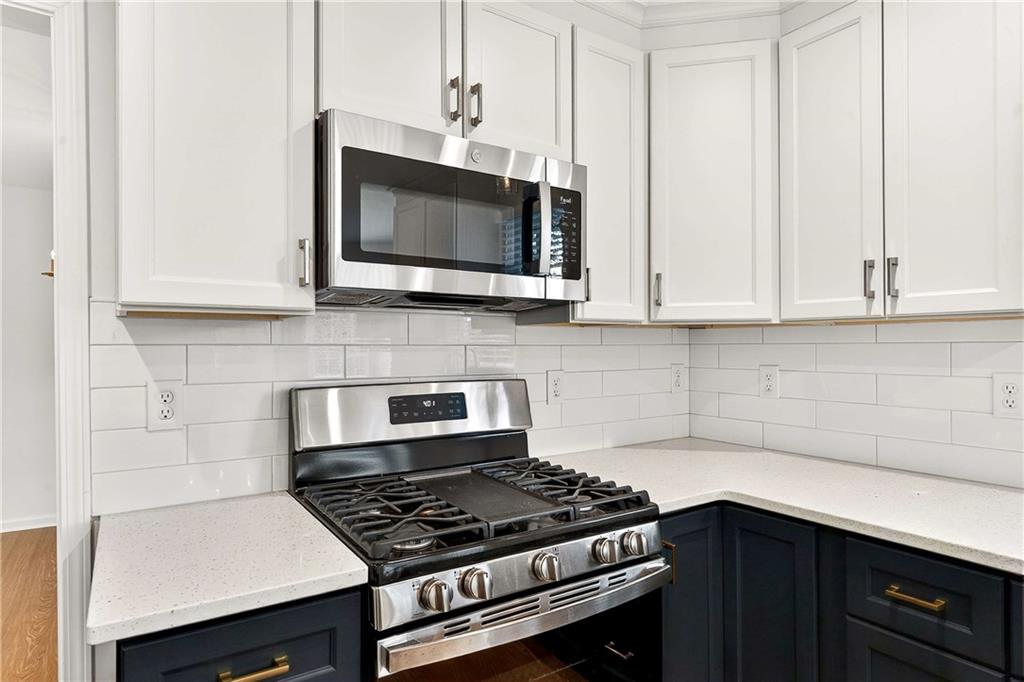 1028 Boston Ridge Woodstock, GA 30189 - Photo 11 of 37 a kitchen with stainless steel appliances a stove a microwave and cabinets