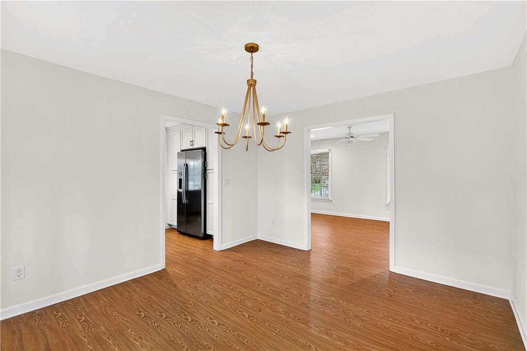 1028 Boston Ridge Woodstock, GA 30189 - Photo 14 of 37 a view of an empty room with wooden floor and a chandelier