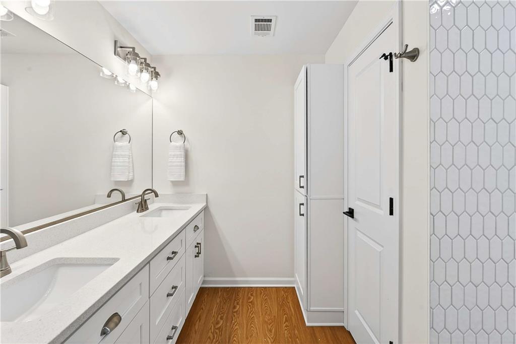 1028 Boston Ridge Woodstock, GA 30189 - Photo 22 of 37 a bathroom with a double vanity sink a large mirror and shower