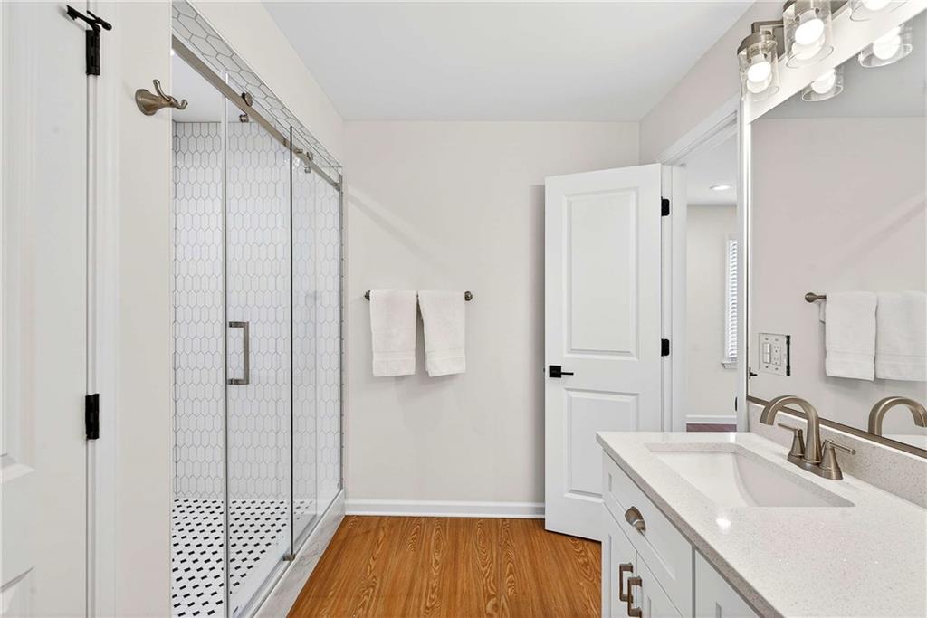 1028 Boston Ridge Woodstock, GA 30189 - Photo 23 of 37 a bathroom with a sink a mirror and shower