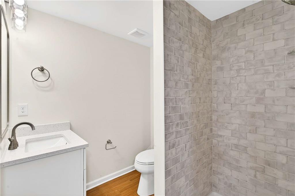 1028 Boston Ridge Woodstock, GA 30189 - Photo 33 of 37 a bathroom with a sink a toilet and a mirror