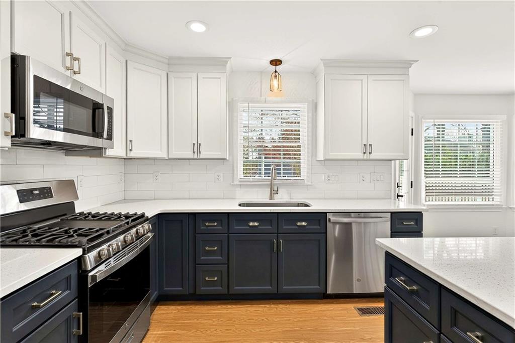 1028 Boston Ridge Woodstock, GA 30189 - Photo 9 of 37 a kitchen with stainless steel appliances granite countertop a sink stove a microwave and cabinets
