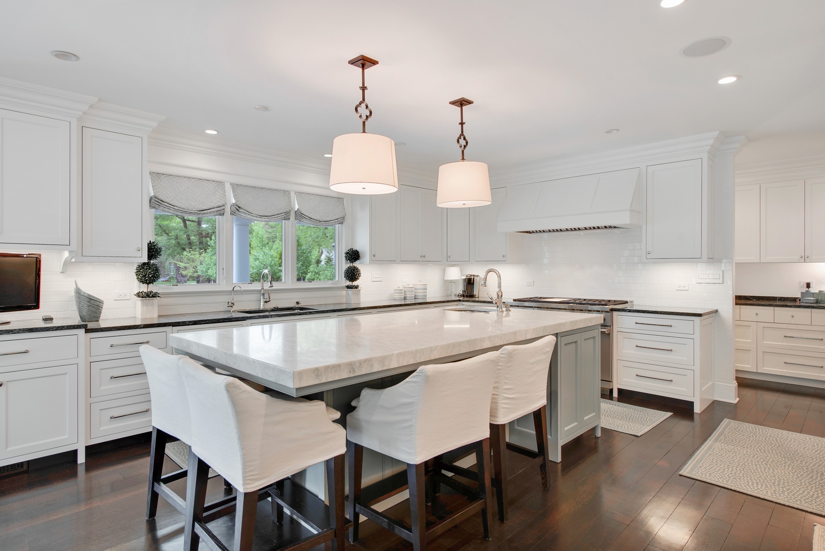 36 Hibbard Road Winnetka, IL 60093 - Photo 9 of 31 a kitchen with kitchen island granite countertop a sink and white cabinets