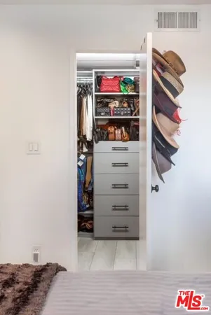 a view of walk in closet with clothes and shoes