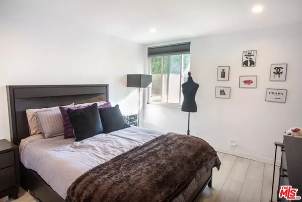 a bedroom with a bed and a potted plant