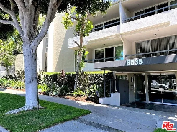 a view of a swimming pool with a bench and some trees in the background