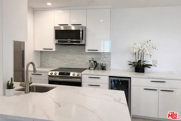 a kitchen with a sink and a stove top oven with wooden floor