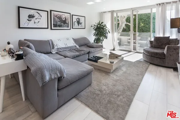 a living room with furniture and large windows