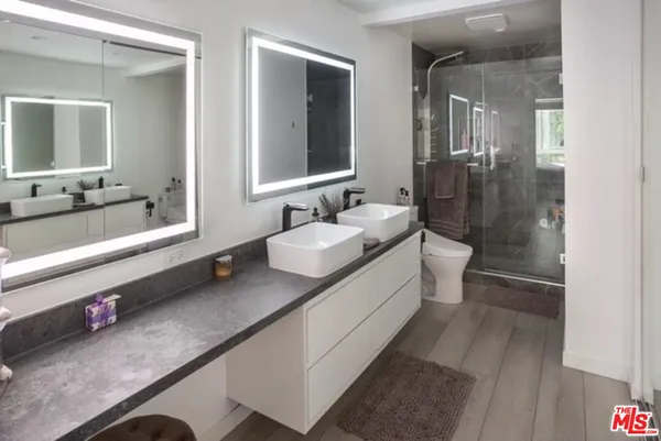 a bathroom with a sink a large mirror and a bathtub