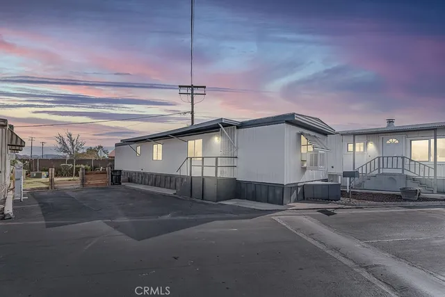 a big room with chandelier fan and windows