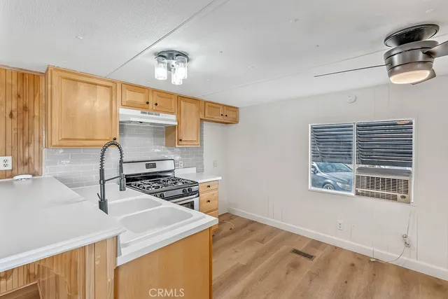 a kitchen with stainless steel appliances a sink a stove and a wooden floors