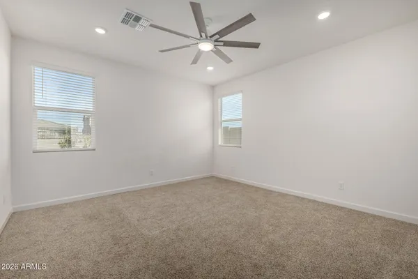 an empty room with windows and fan