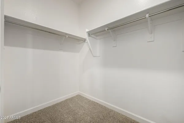 an empty room with a chandelier fan and window