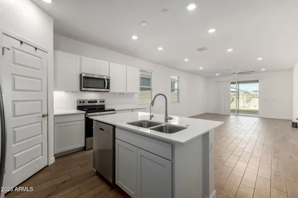 a kitchen with kitchen island granite countertop a sink stainless steel appliances and white cabinets