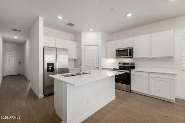 a kitchen with stainless steel appliances granite countertop a sink stove refrigerator and cabinets