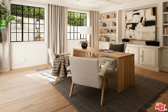 a living room with furniture a floor to ceiling window and wooden floor