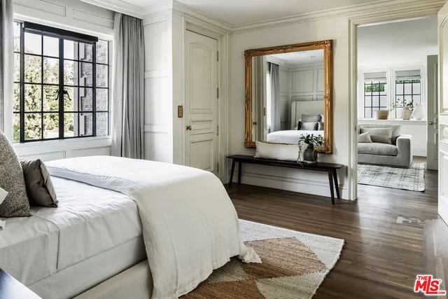 a bedroom with a bed and a couch next to a window