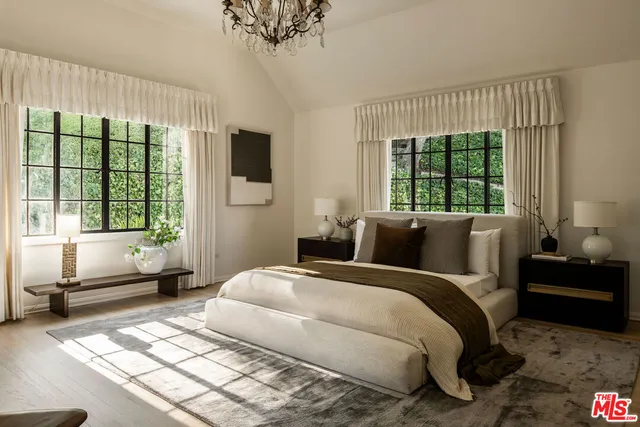 a bedroom with a bed and large windows