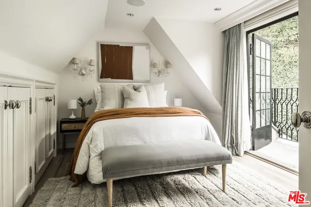 a bedroom with a bed and a large window