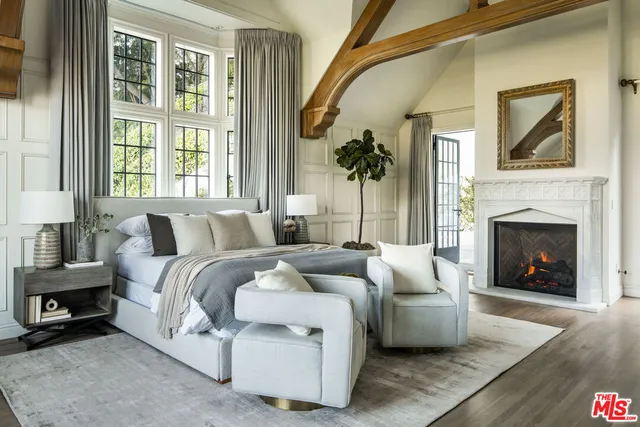 a spacious bedroom with a balcony a bed and a fireplace