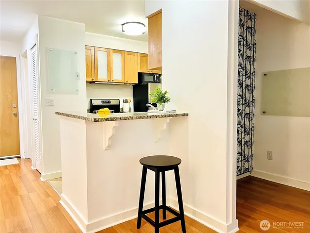 a kitchen with stainless steel appliances a dining table chairs and a refrigerator