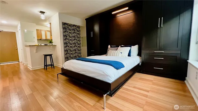 a spacious bedroom with a bed and a wooden floor