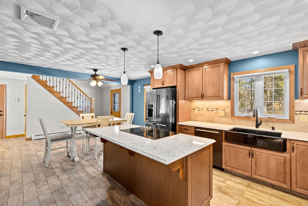 4 Highland Ridge Road Assonet, MA 02702 - Photo 12 of 42 a kitchen with a stove a sink a kitchen island with a dining table and chairs
